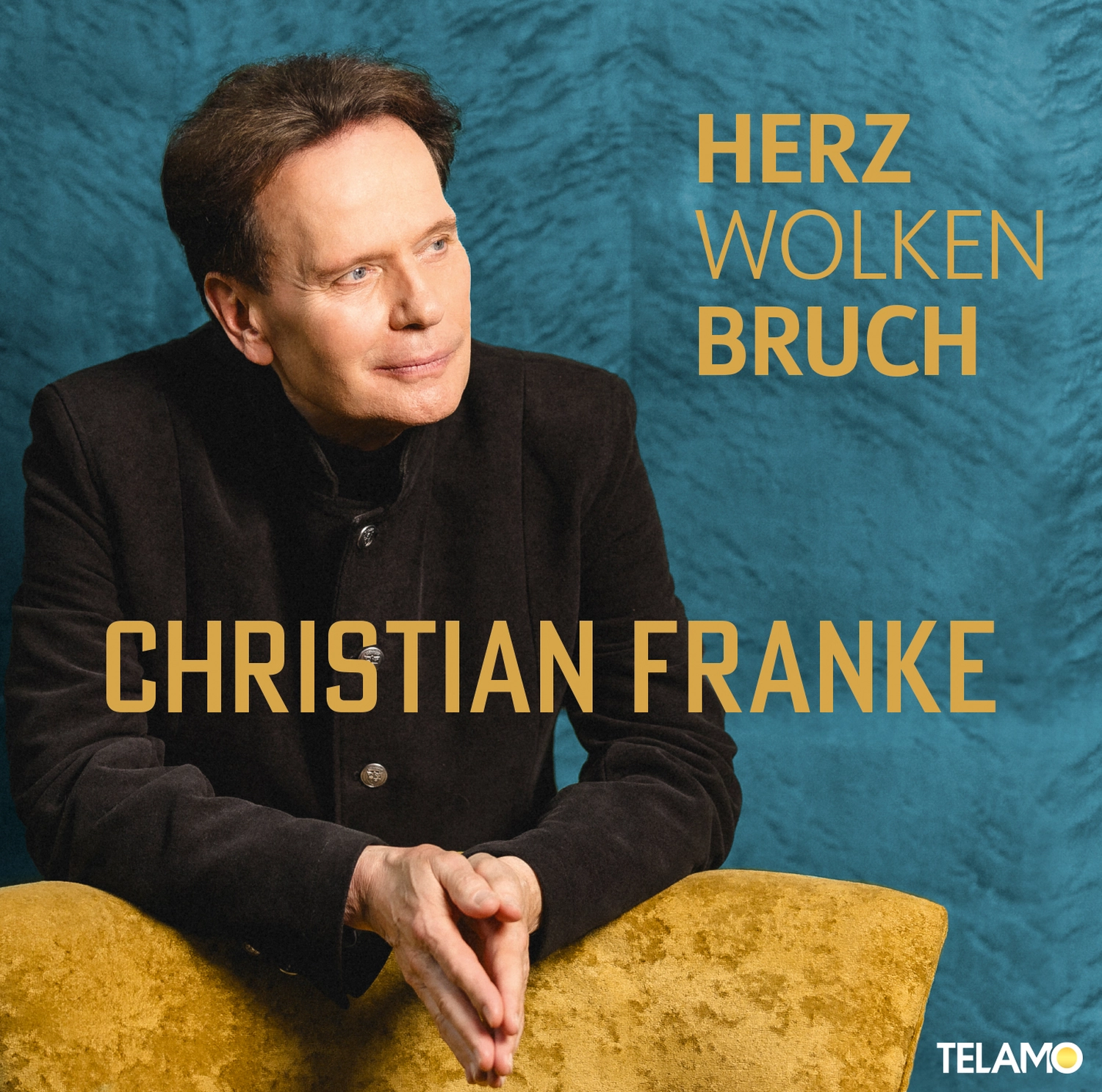 CF Christian Franke - Musiker - Christian Franke sitzt mit verschränkten Händen auf einem gelben Stuhl vor einem blauen, strukturierten Hintergrund mit den Aufschriften 'HERZ WOLKEN BRUCH' und 'CHRISTIAN FRANKE'